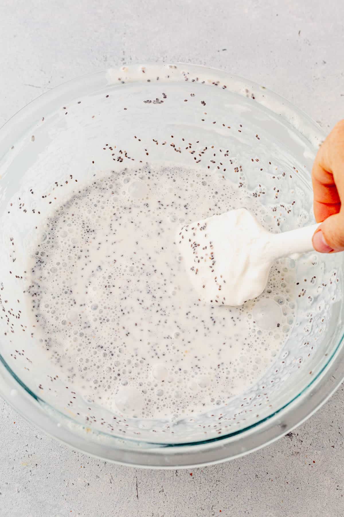 mixing chia yogurt in a glass bowl