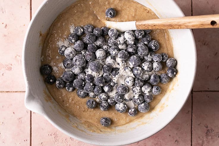 fresh blueberries on top of muffin batter in a bowl