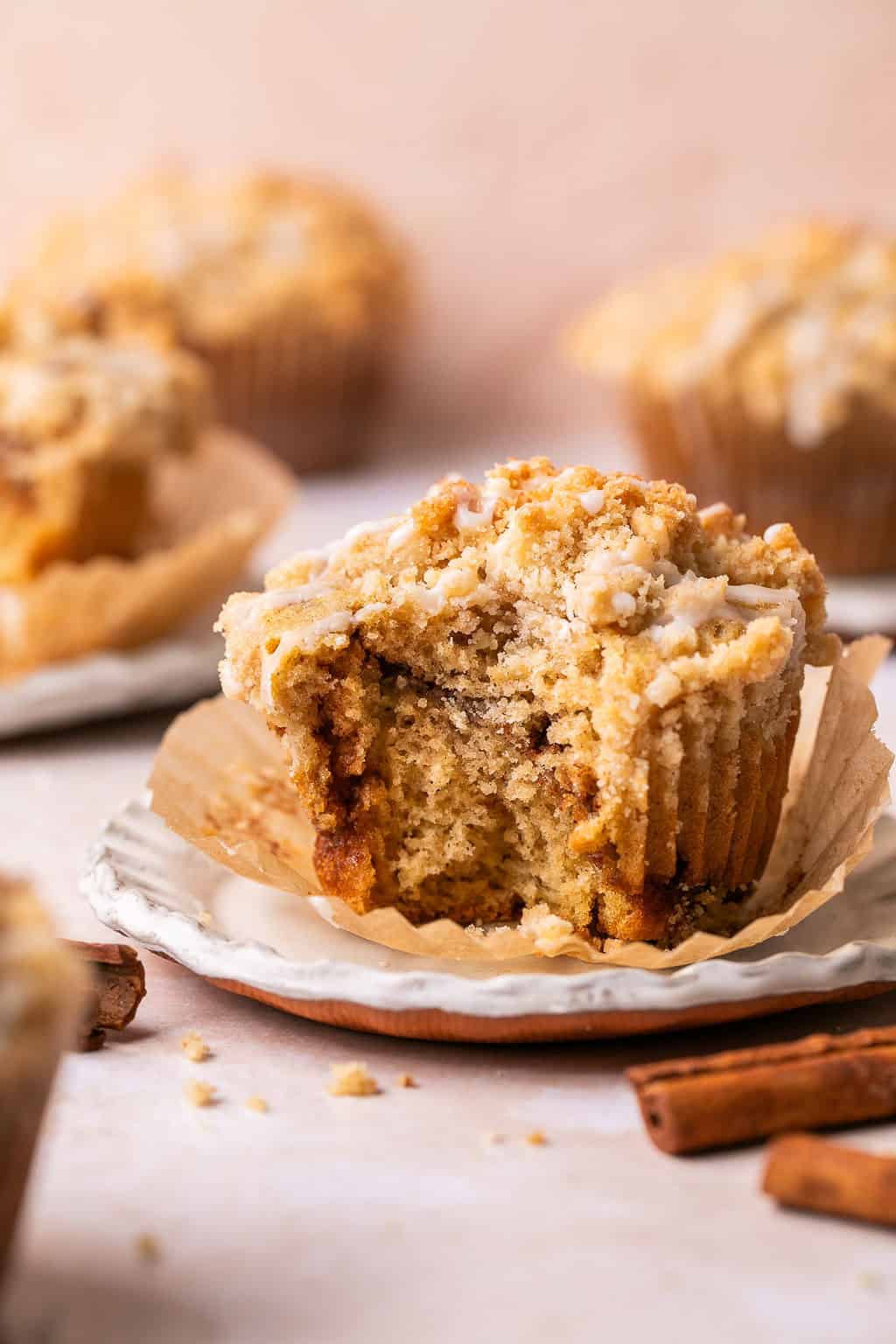 a bite taken out of a coffee cake muffin with crumb topping