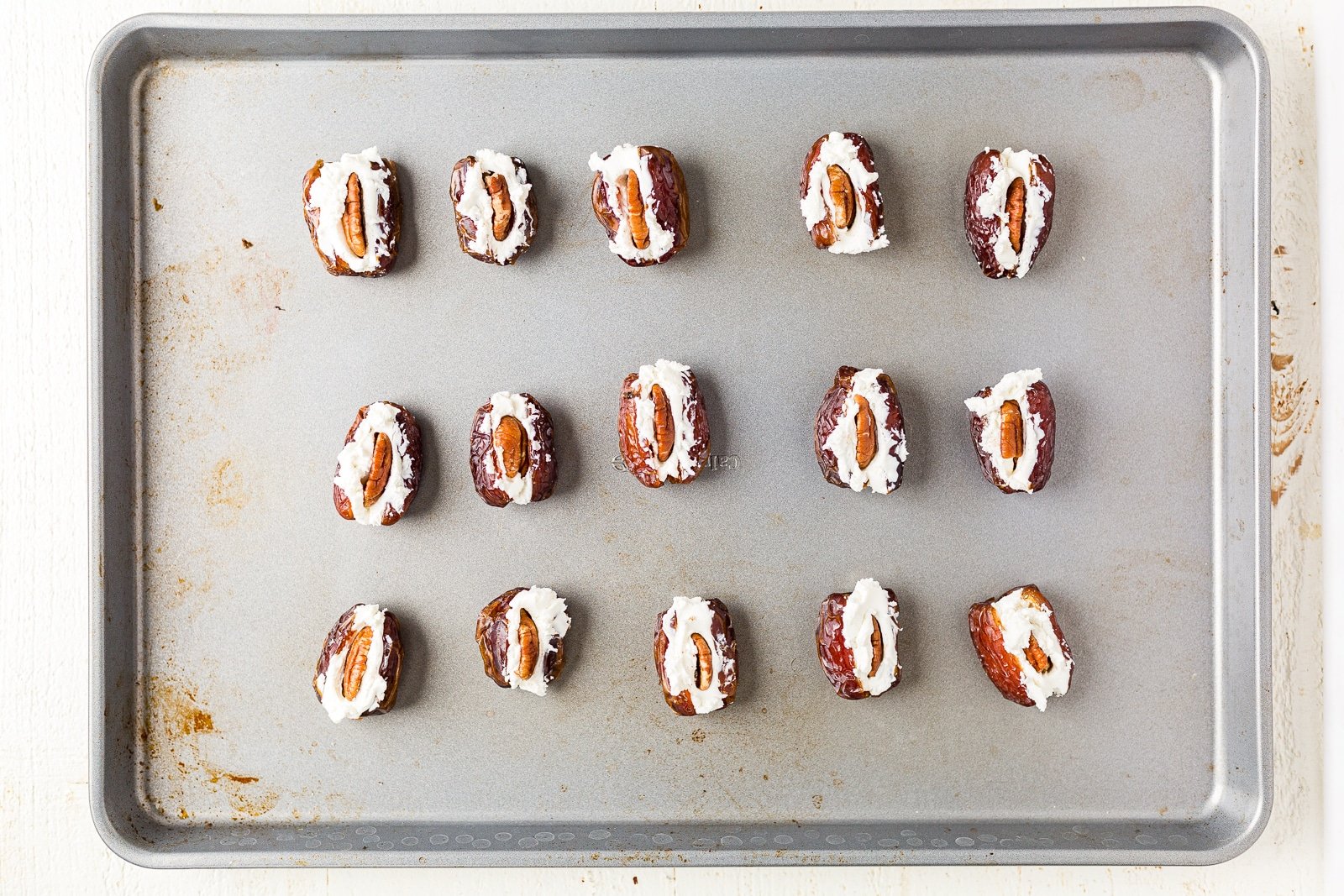 goat cheese stuffed inside dates on a sheet pan.