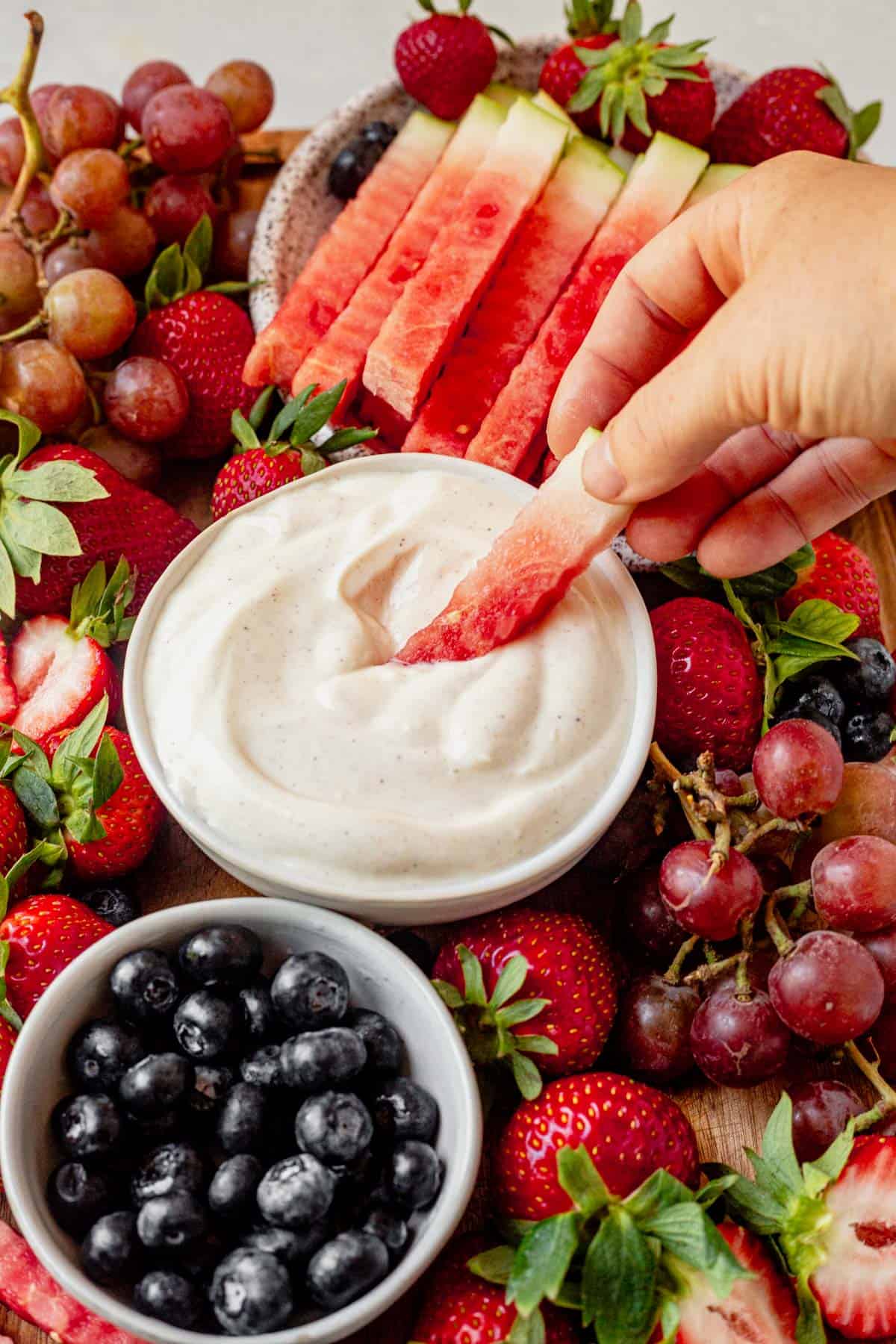 dipping watermelon into yogurt fruit dip