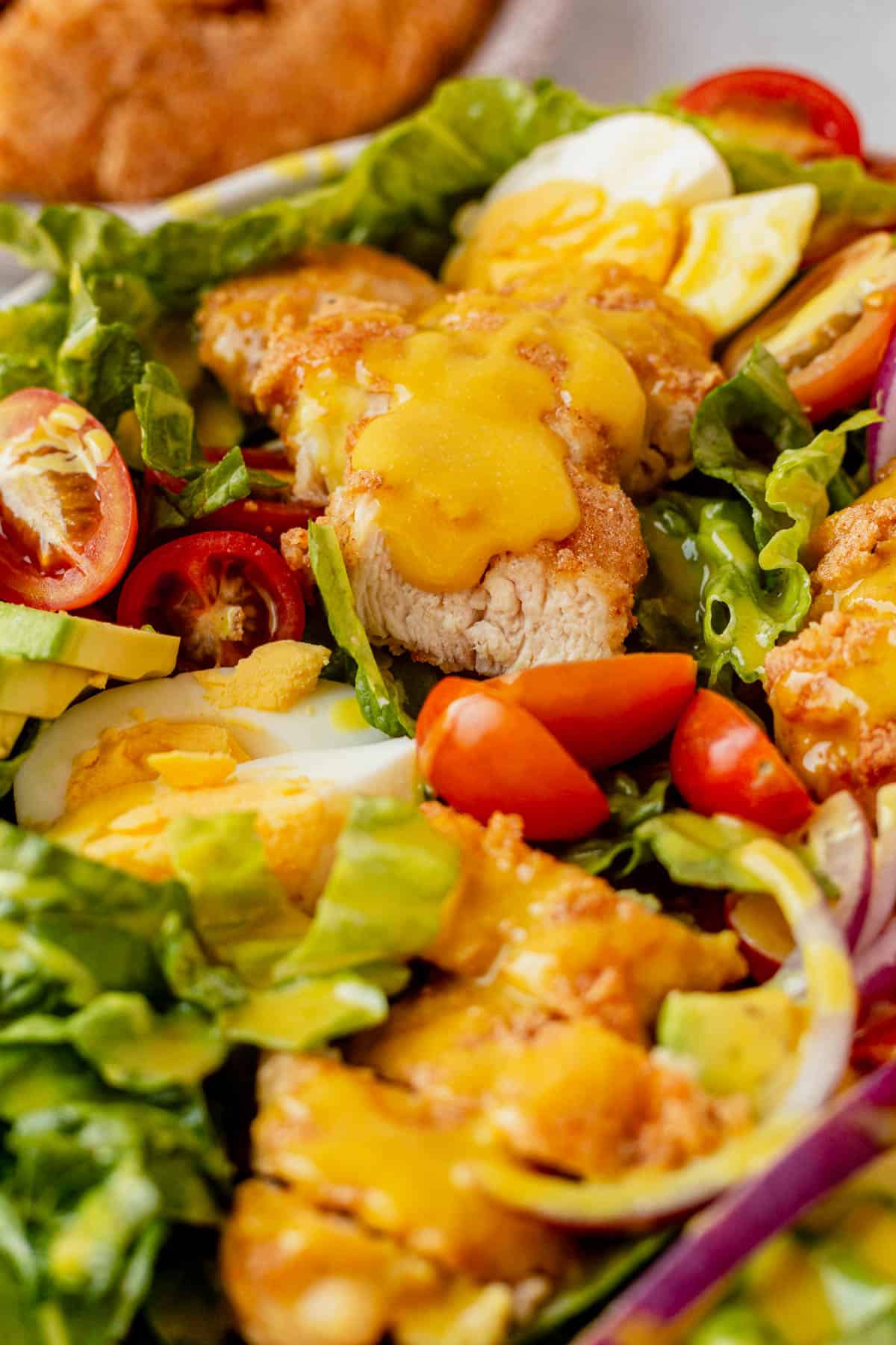 honey mustard dressing on top of crispy chicken salad