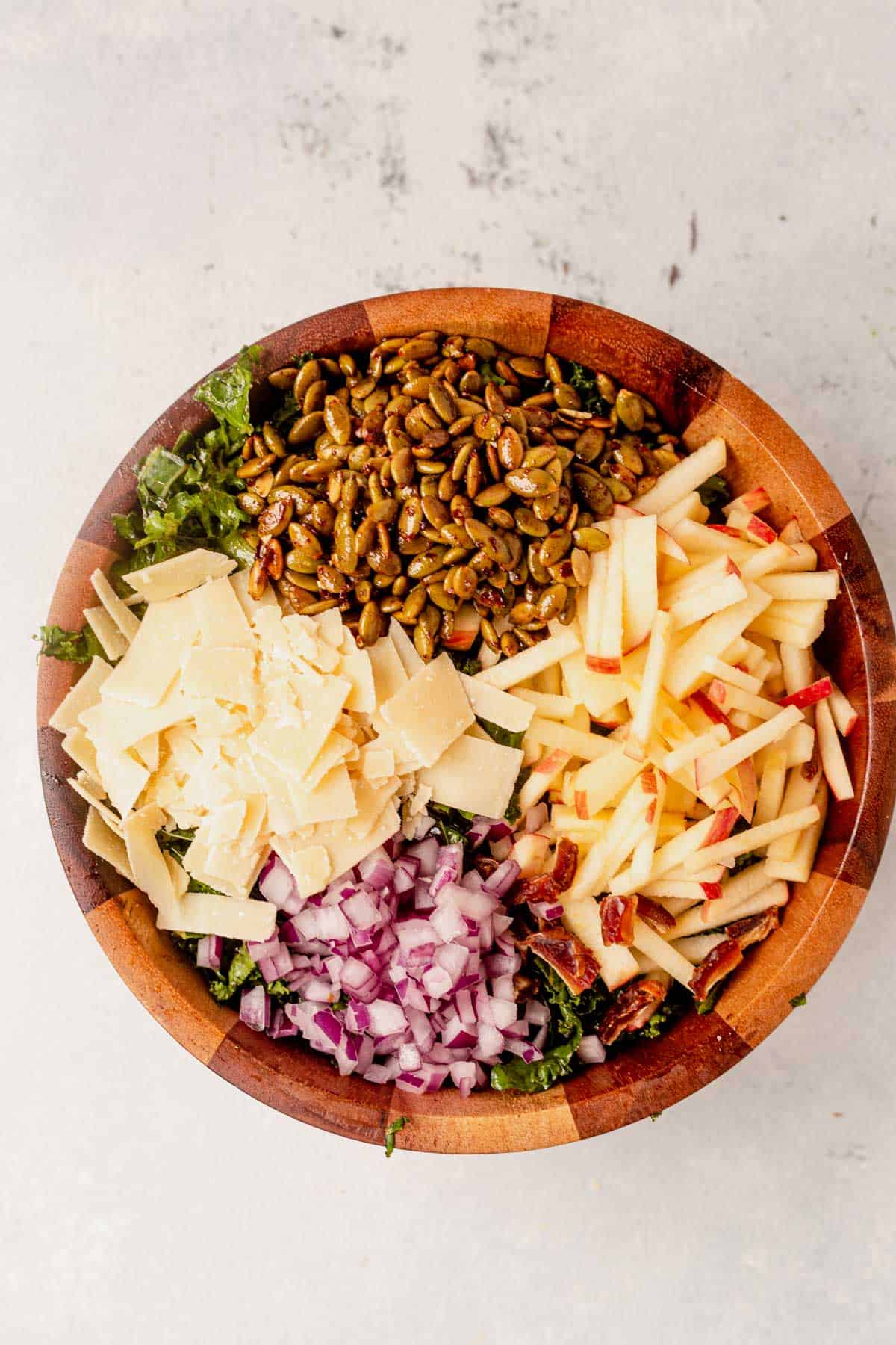 pumpkin seeds, apple, and parmesan on top of kale