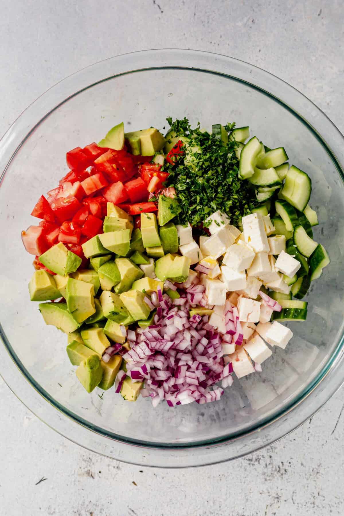 greek salad ingredients in a mixing bowl