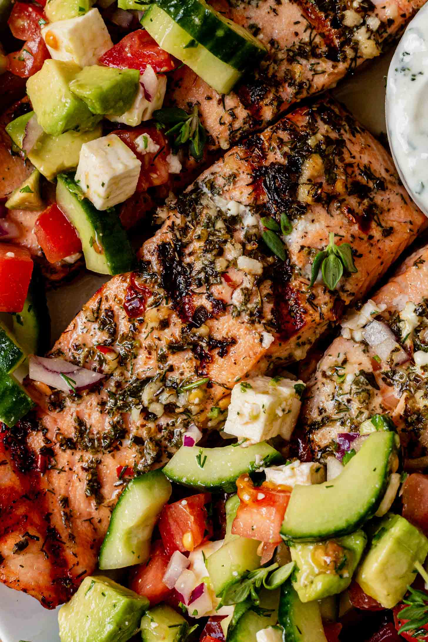 greek salmon on a plate with greek salad