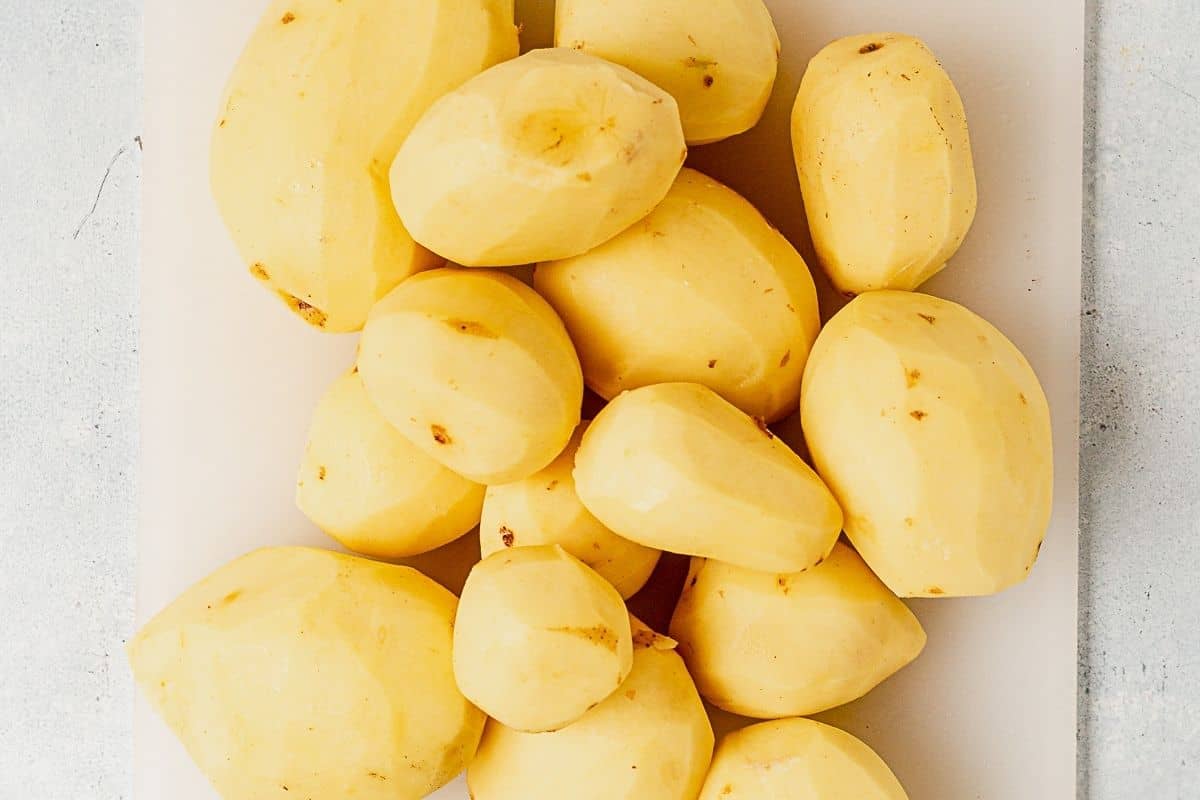 peeled yukon gold potatoes on a cutting board