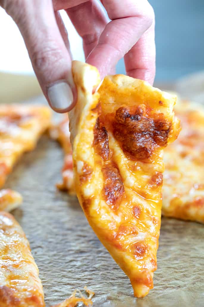 Hand folding a slice of NY style gluten free pizza