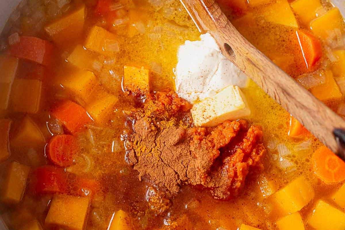 cream, butter, and spices on top of squash soup