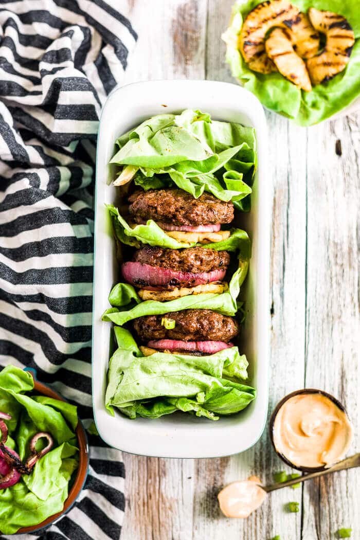 pineapple teriyaki burgers on a serving dish with grilled pineapple and onion