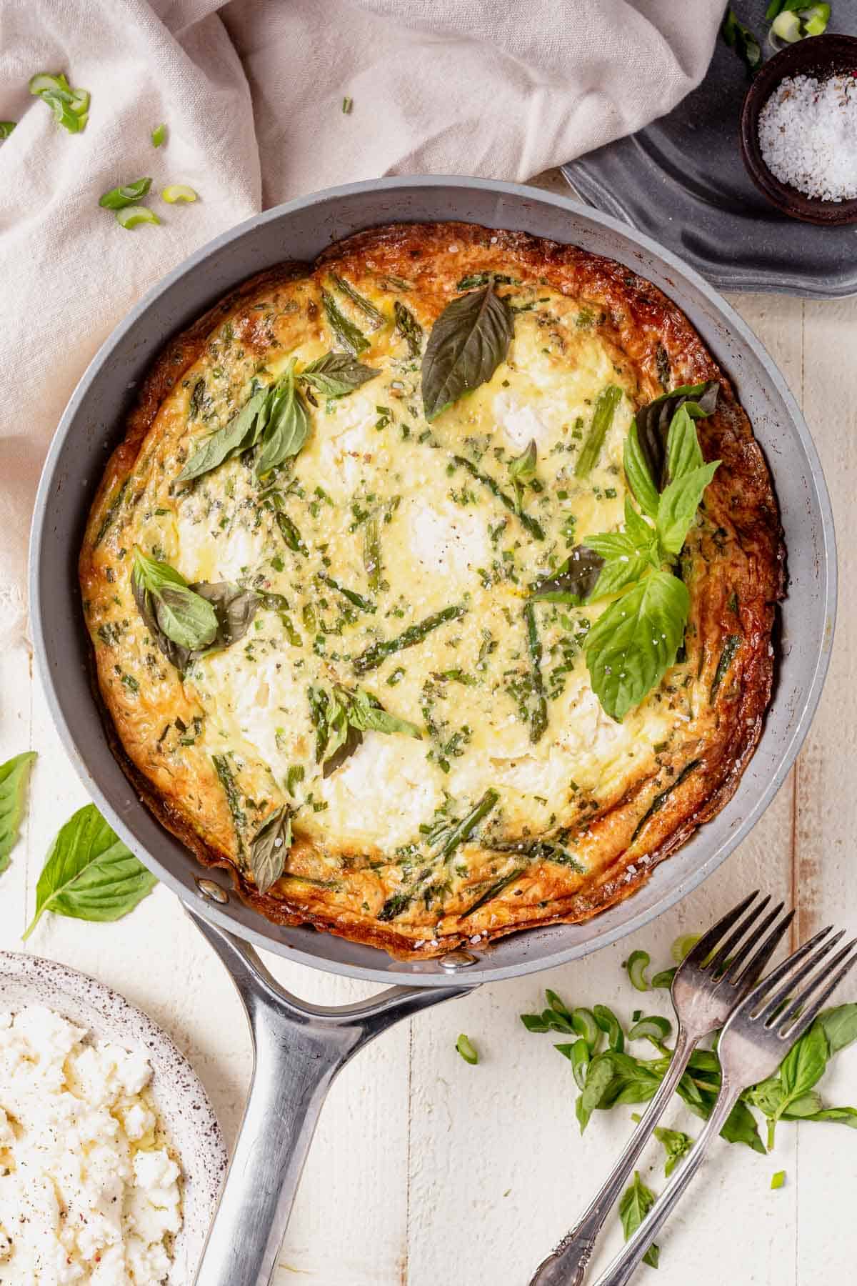 asparagus frittata in a skillet with fresh basil