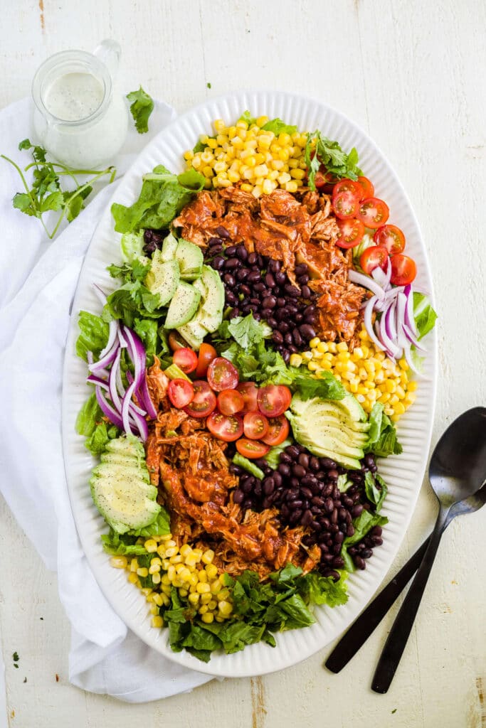 bbq chicken salad on a white platter with cilantro lime ranch