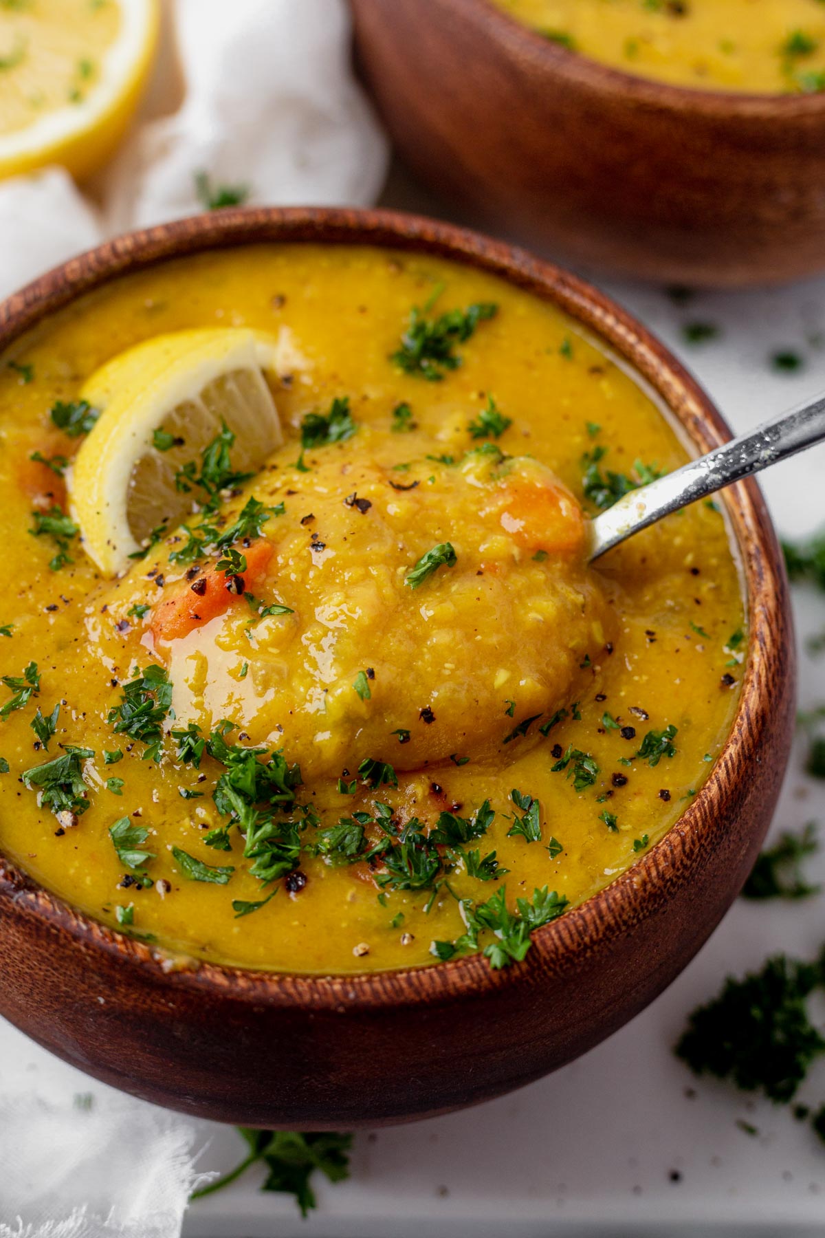 scooping lemon lentil soup from a bowl