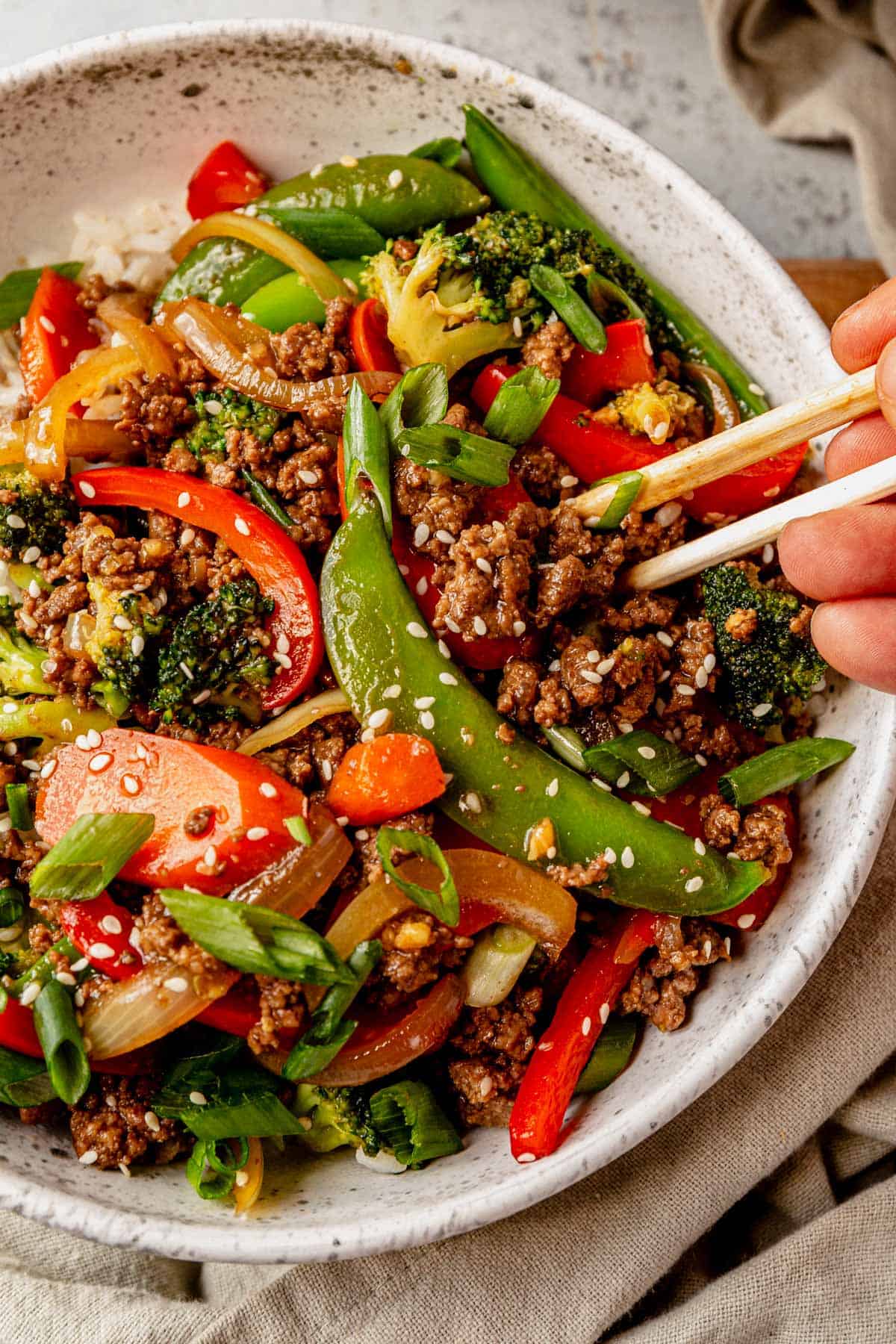 picking up ground beef stir fry with chopsticks