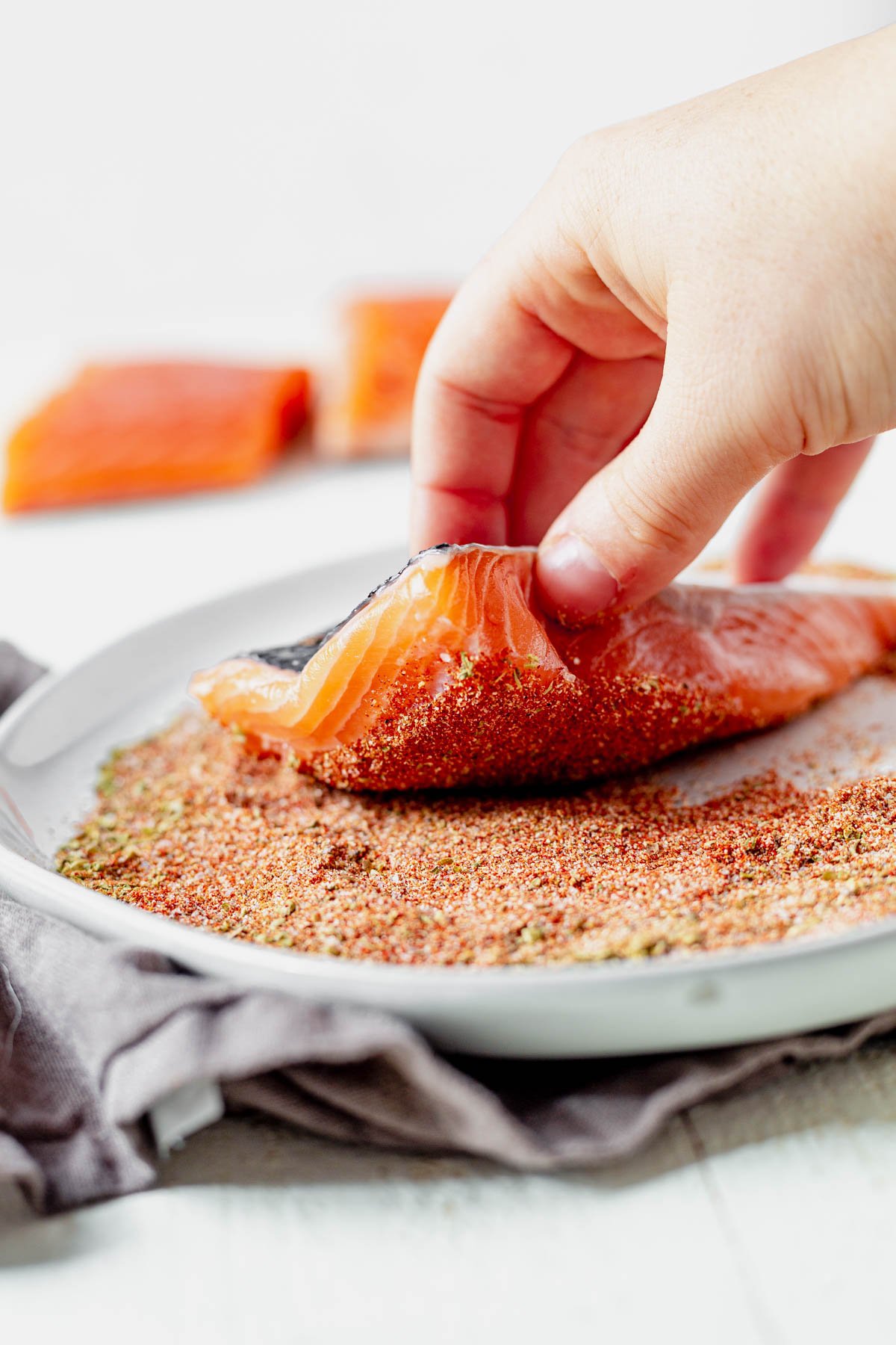 raw salmon dipping in blackened seasoning