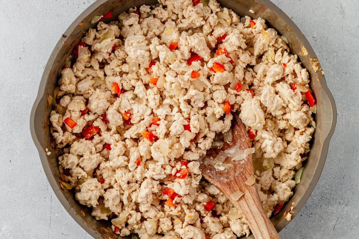 ground chicken, onion, and peppers cooked in a skillet