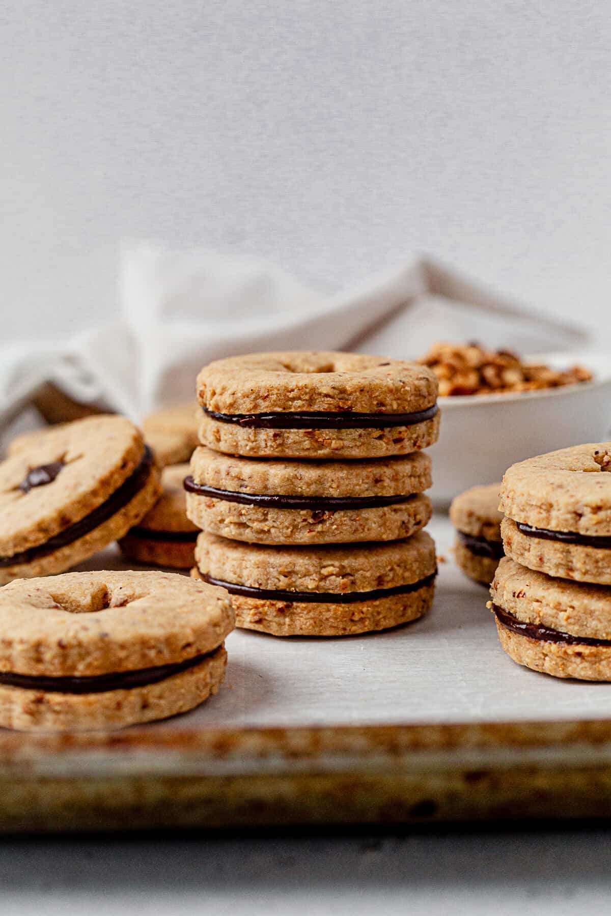 a stack of three hazelnut shortbread cookie sandwiches on a cookie sheet