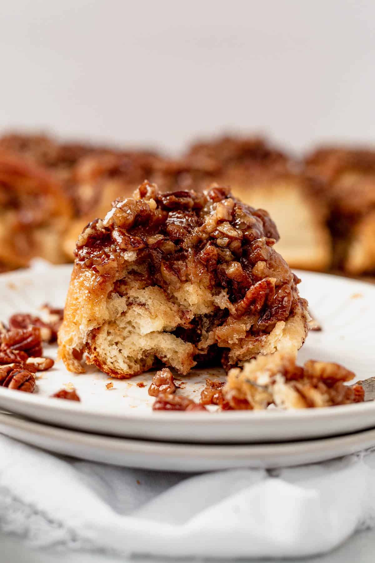 a bite taken out of a sticky bun on a plate