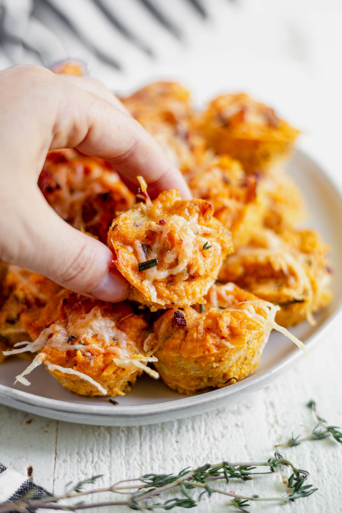 hand picking up a sweet potato puff from an appetizer plate