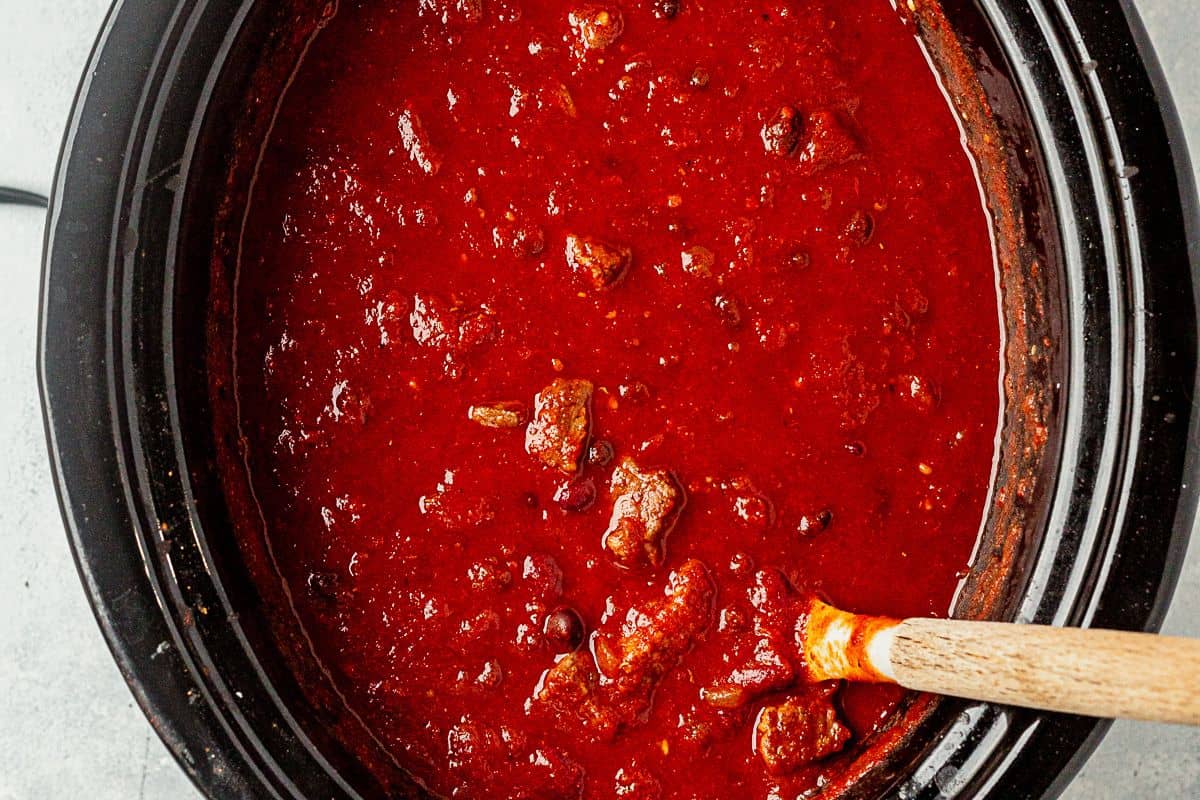 freshly cooked crock pot steak chili with a ladle