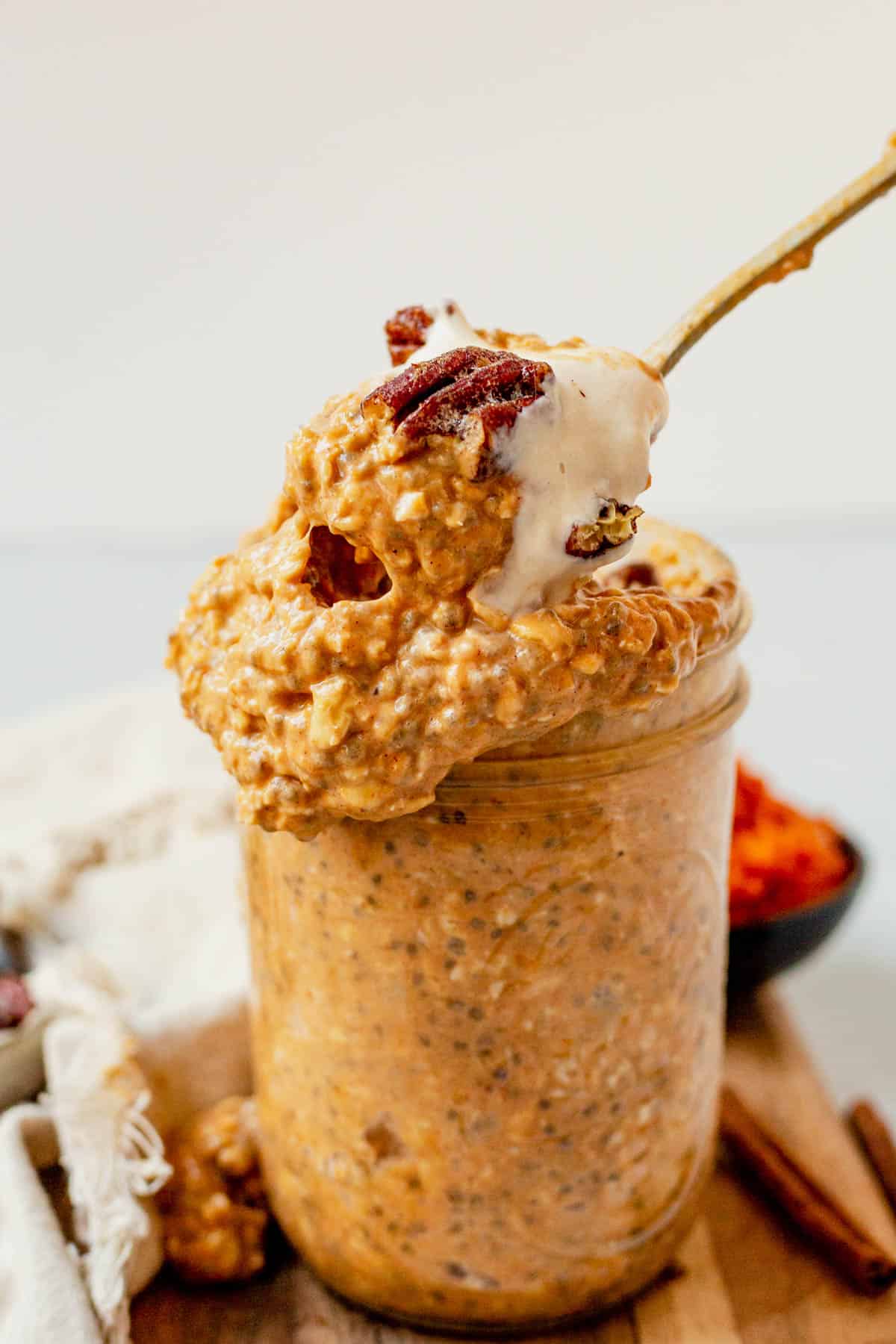 scooping pumpkin overnight oats out of a jar