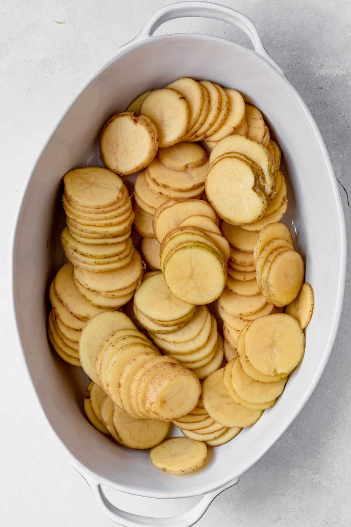 thinly sliced potatoes in a dish