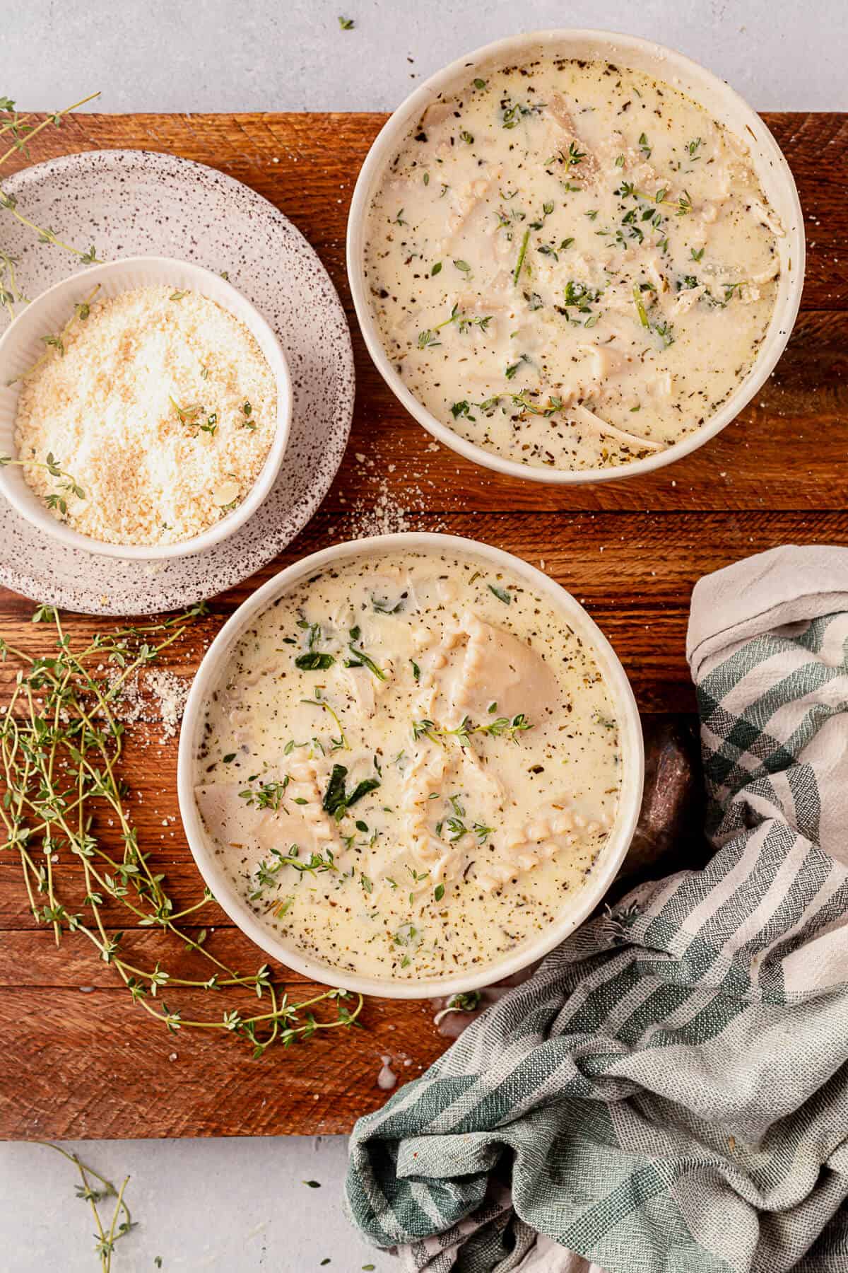 two bowls of creamy white chicken lasagna soup with parmesan cheese