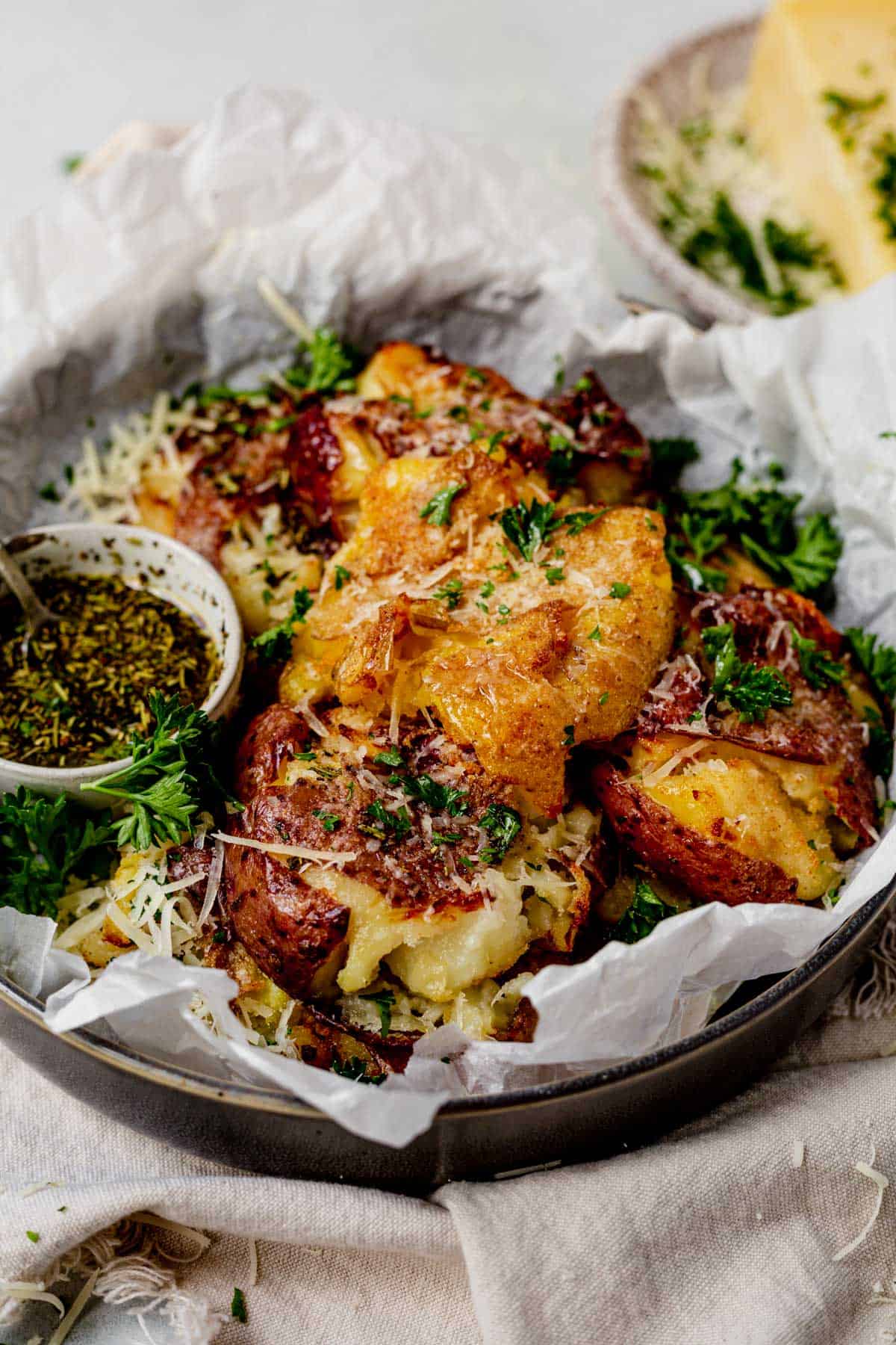 air fryer smashed potatoes in a serving bowl with parmesan cheese