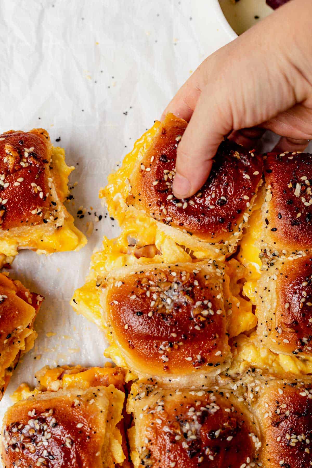 someone grabbing a breakfast slider from the tray