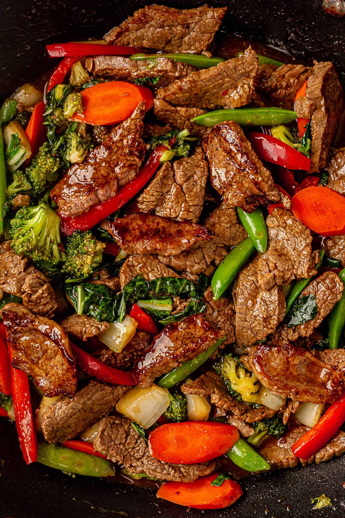 freshly cooked flank steak stir fry in a wok with homemade teriyaki sauce