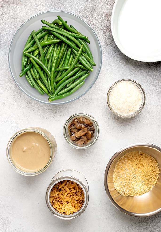 Overhead image of green beans, cooked mushrooms, grated parm, cream of mushroom soup, crispy fried onions and gluten free breadcrumbs