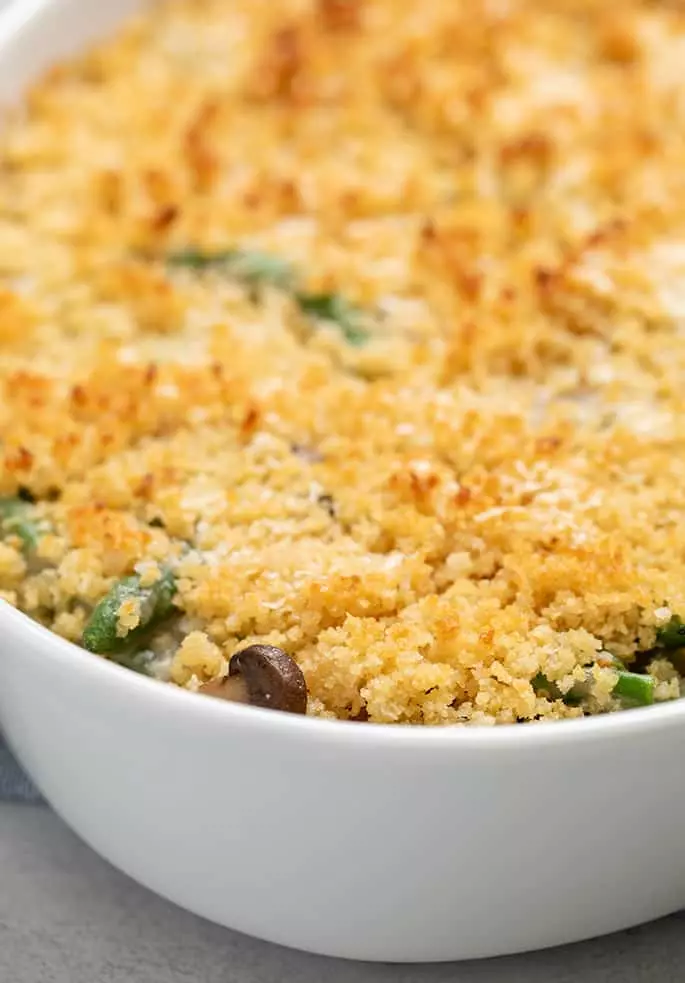 Closeup image of baked gluten free green bean casserole with browned breadcrumbs on top without crispy fried onions