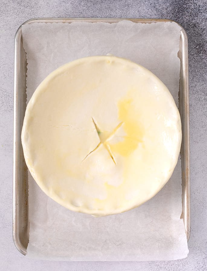 Overhead image of pie crust covering round casserole dish