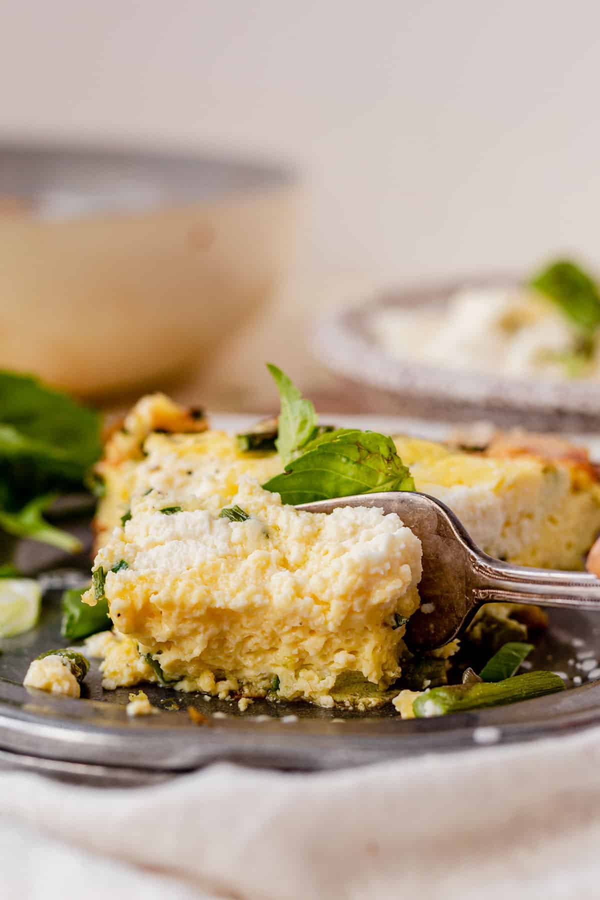 a fork cutting into a piece of asparagus frittata