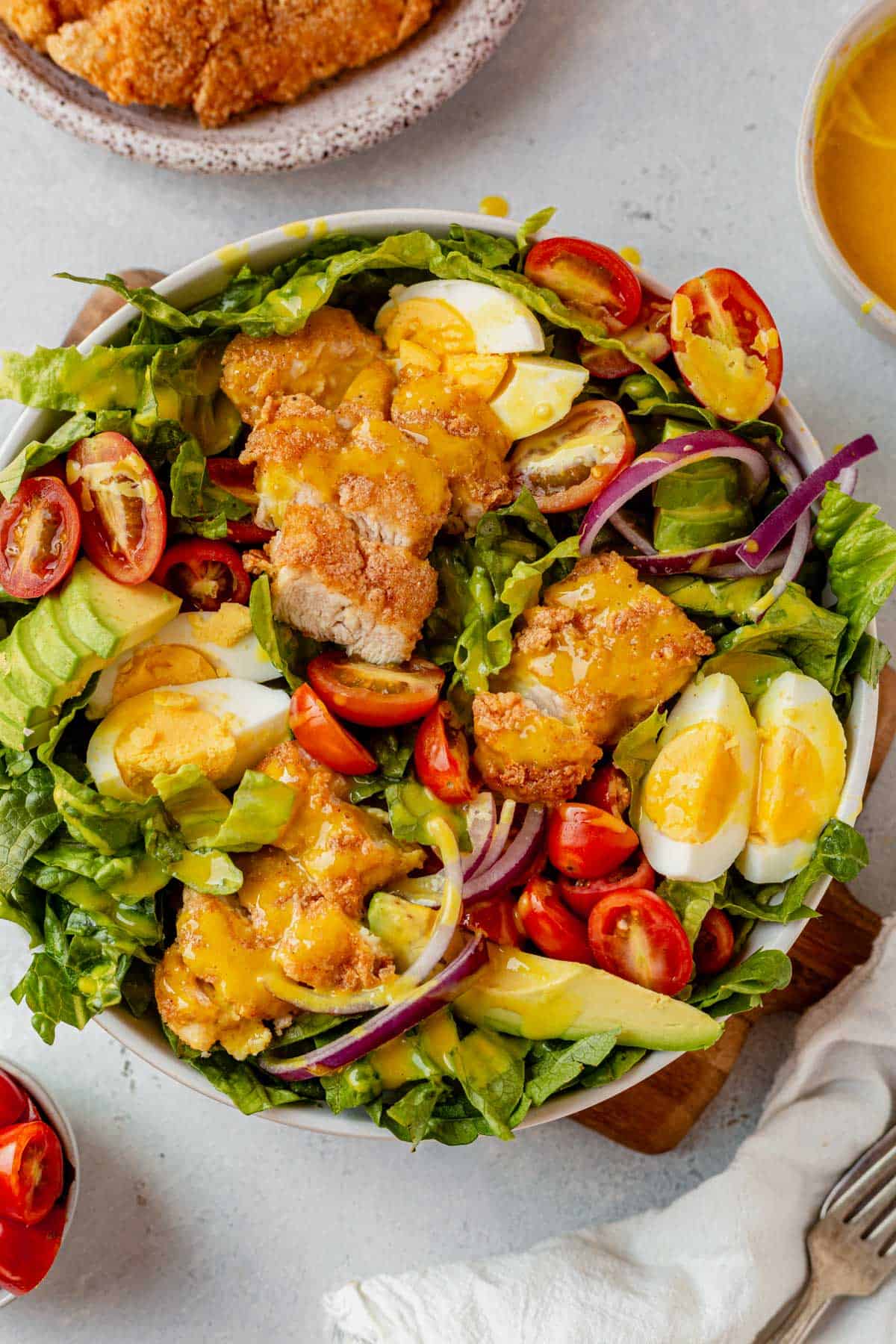 crispy chicken salad in a bowl with honey mustard dressing