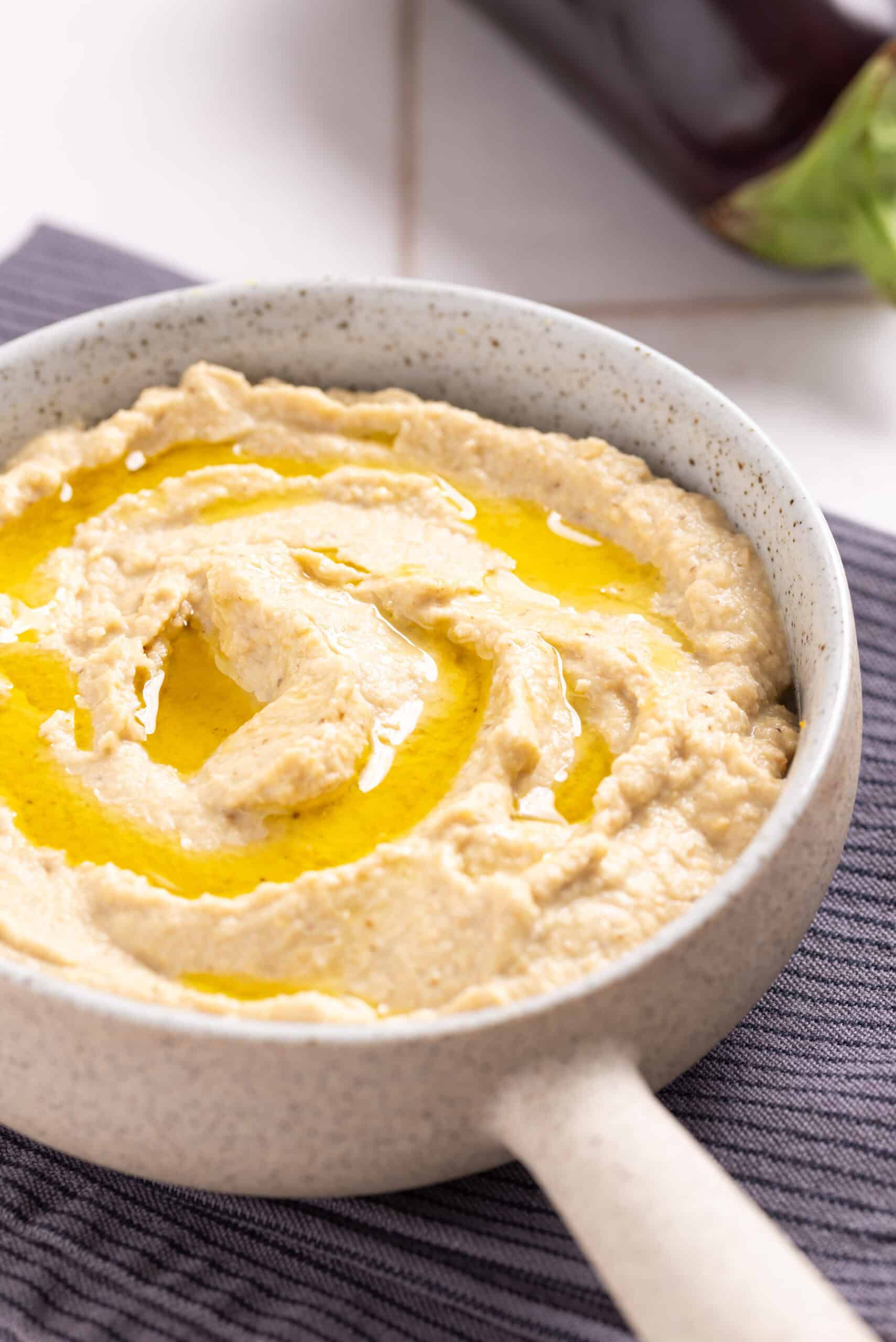 An image of eggplant hummus served n a small saucepan.