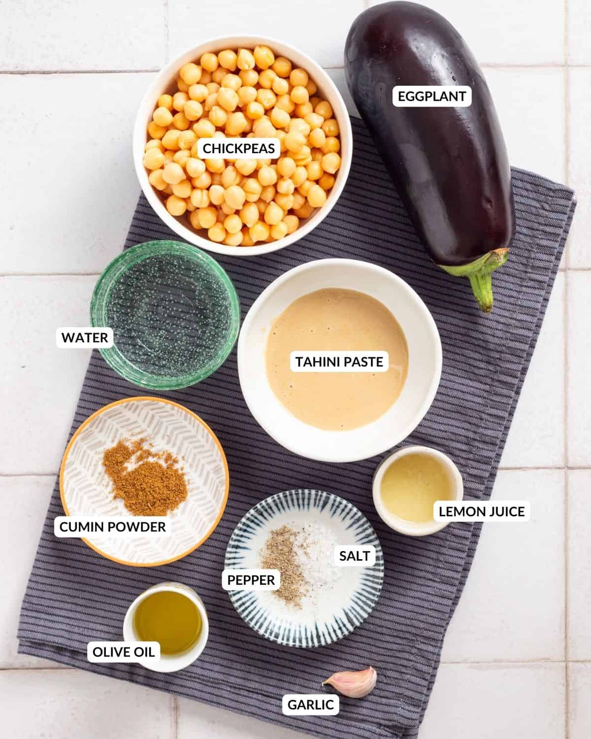 An overhead image of the ingredients of eggplant hummus in separate containers.