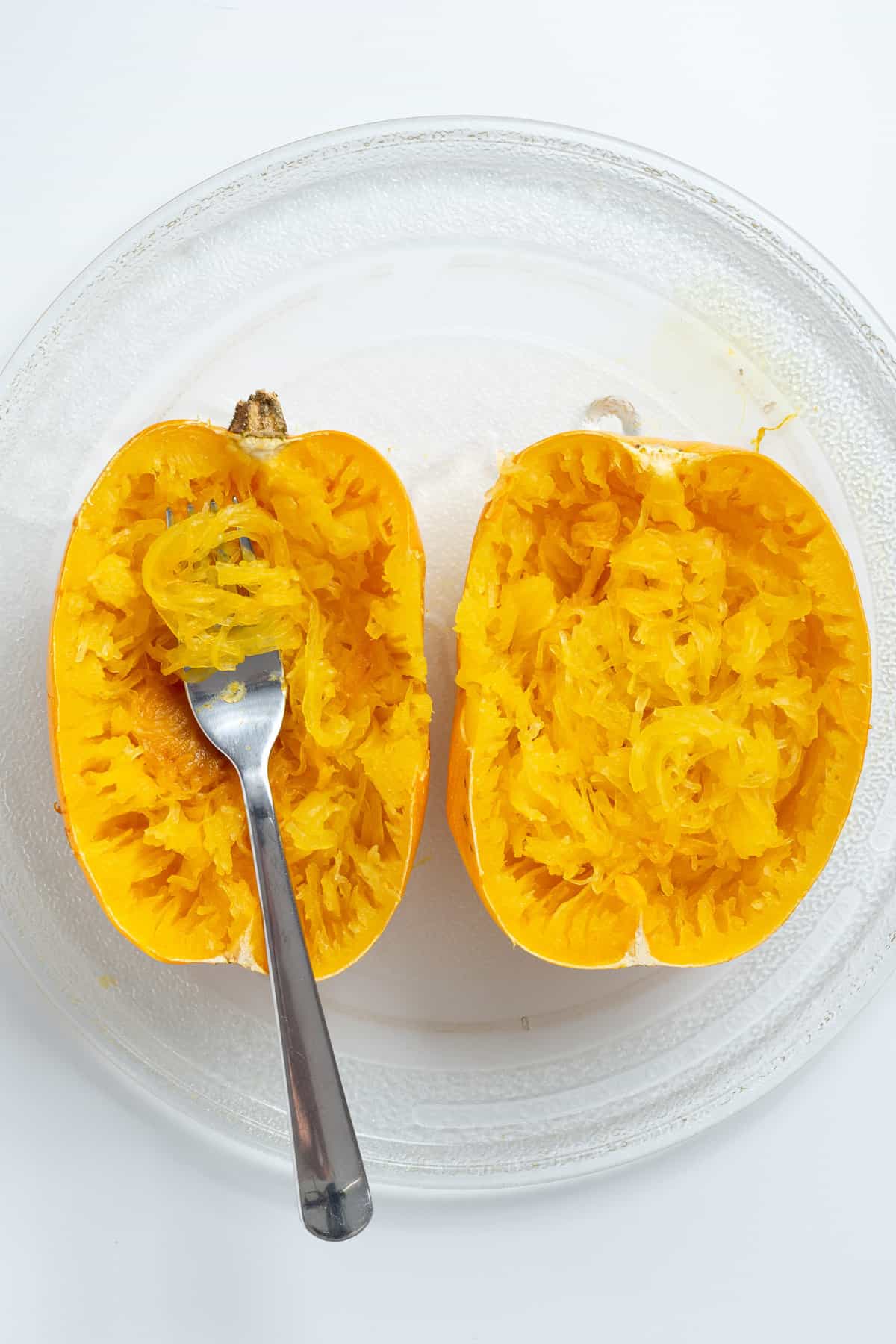 Overhead view showing spaghetti squash noodles fluffed up with fork.