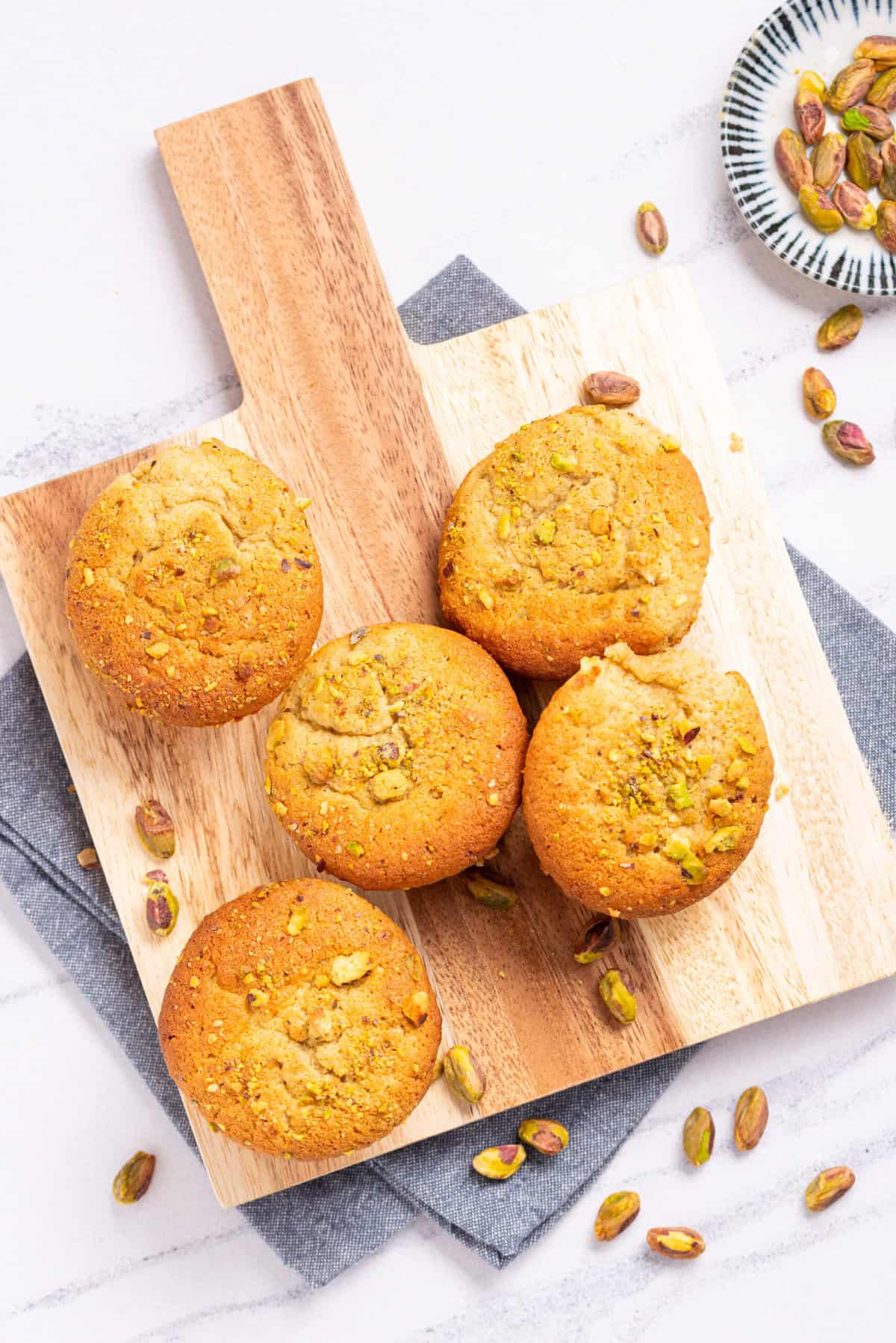 An image of pistachio muffins on a serving board.