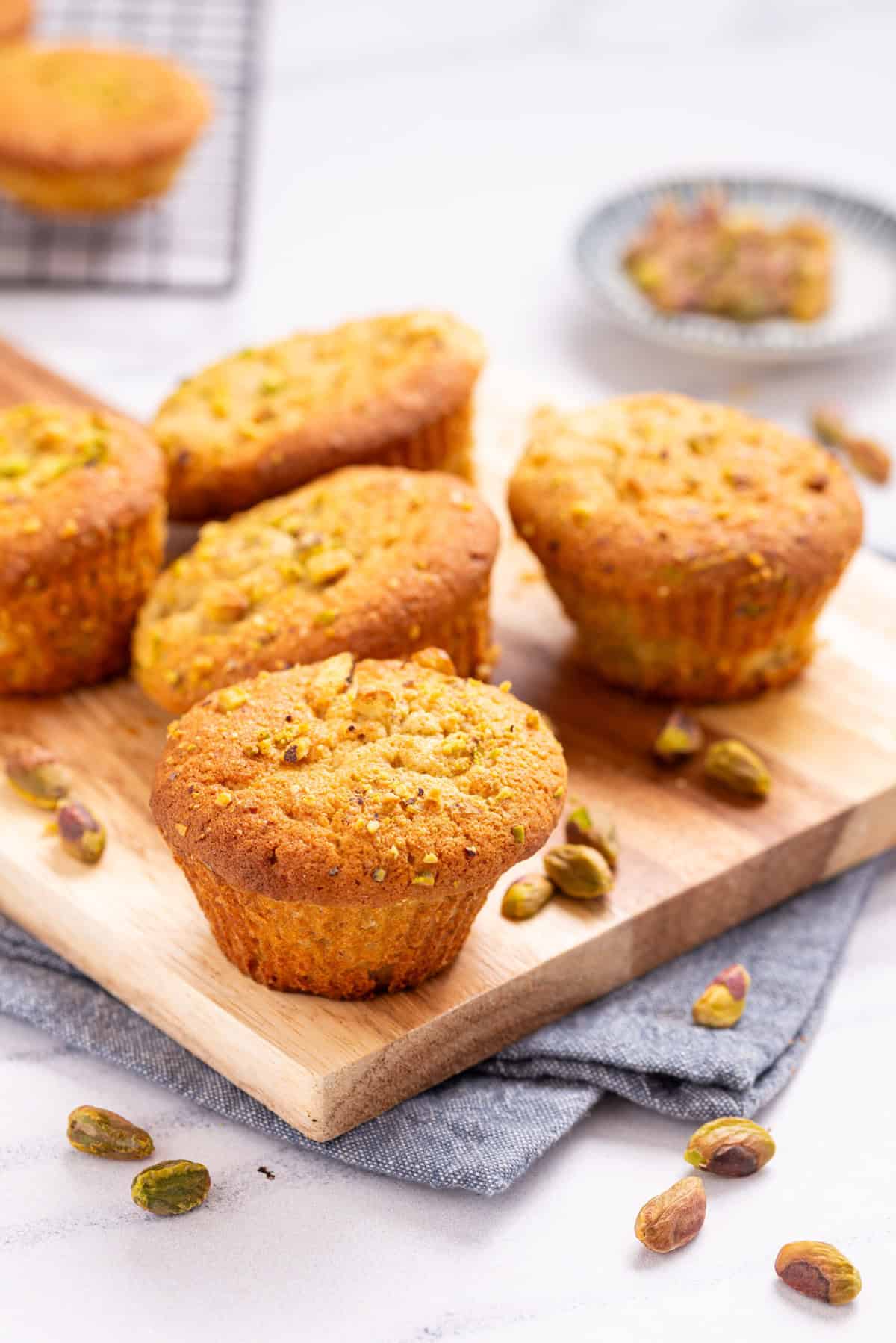 A close up image of pistachio muffins on a serving board.