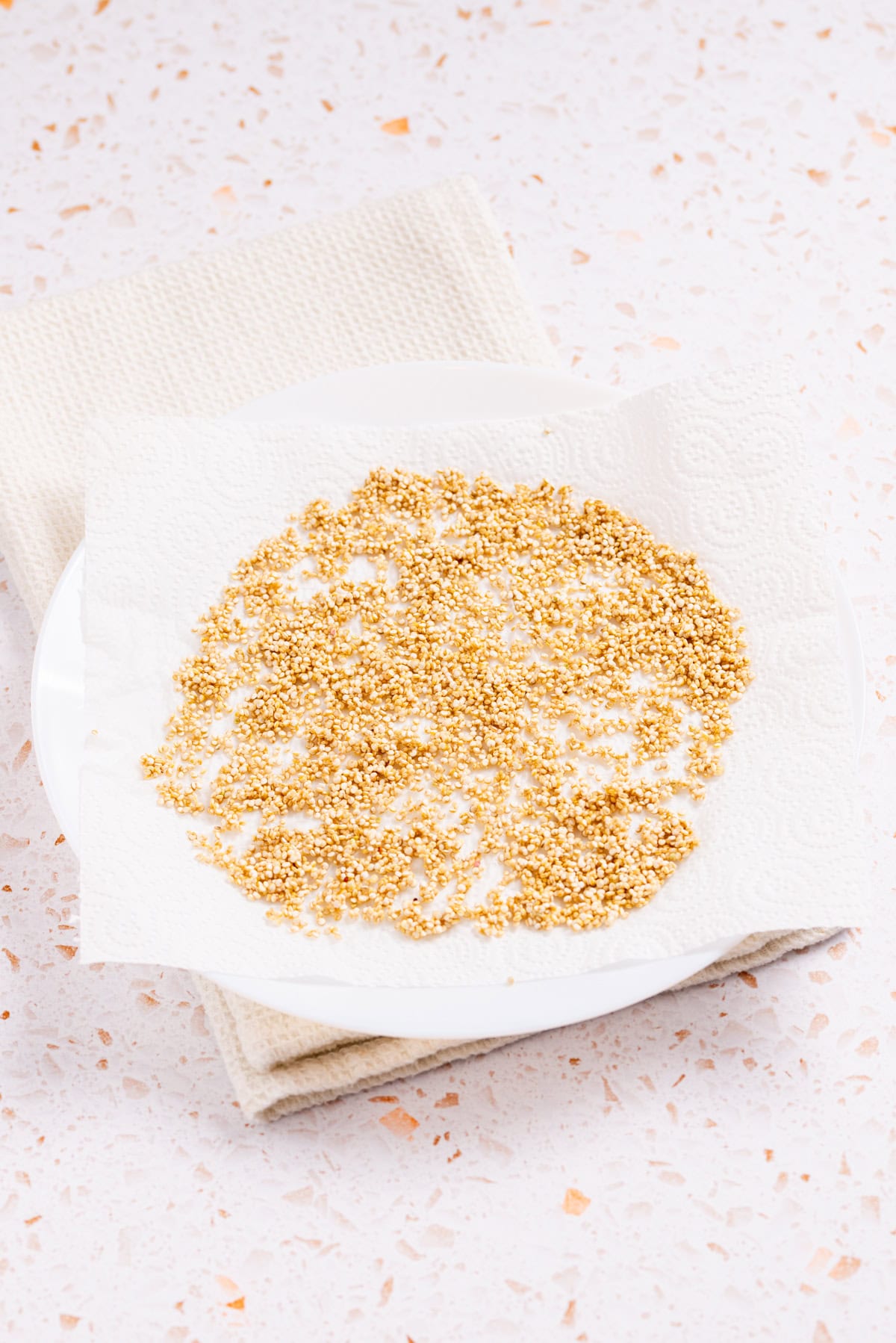 An image of uncooked quinoa on a kitchen towel.