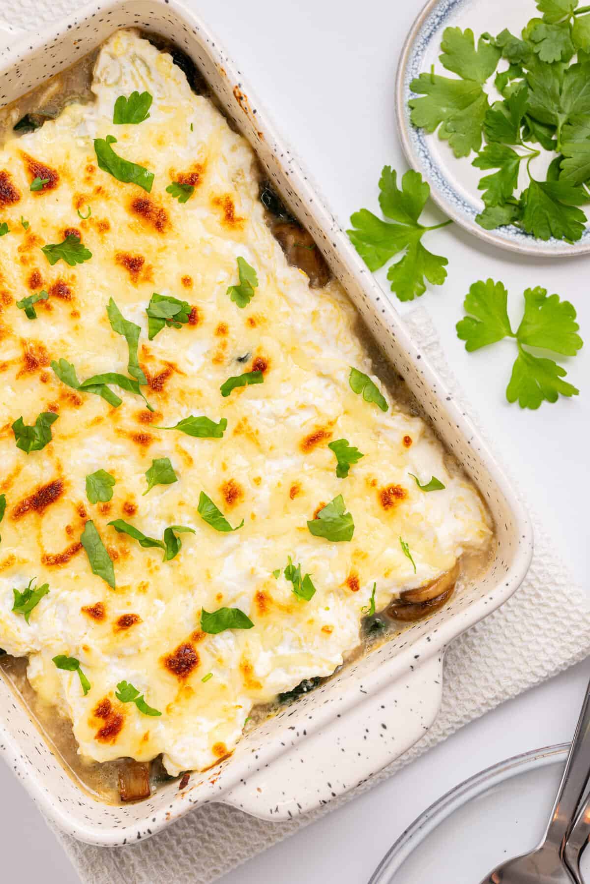 An overhead image of spaghetti squash casserole with fresh basil leaves on top.