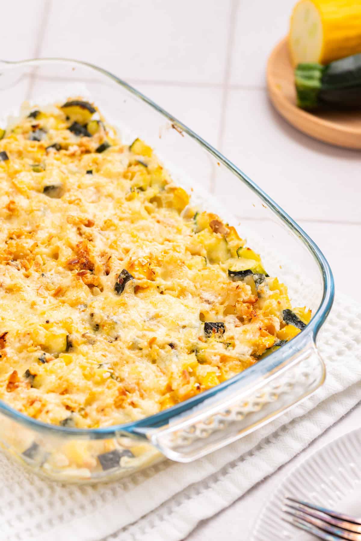 A close up image of squash and zucchini casserole in a baking dish, ready to be served.