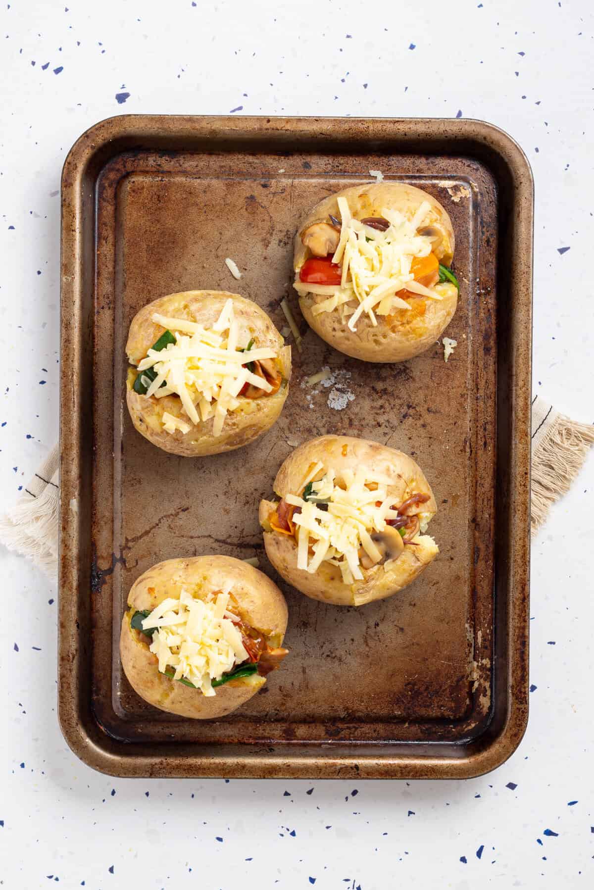 An overhead image of stuffed potatoes in a baking pan.